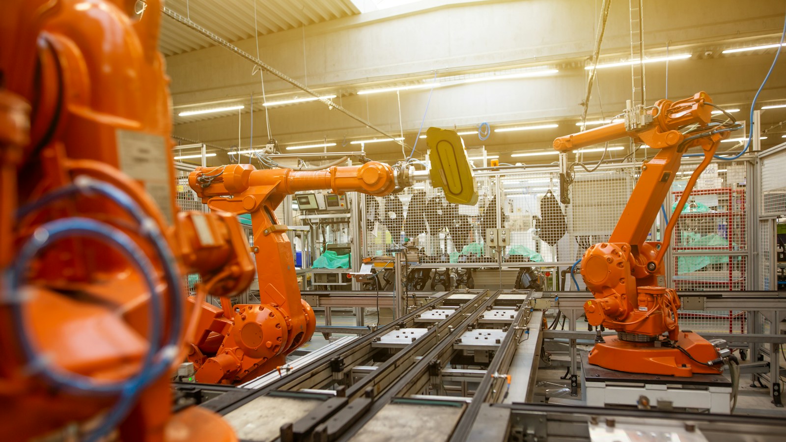 Industrial robotic arms in an automated manufacturing cell, representing the integration challenge for high-temperature flexible sensors.